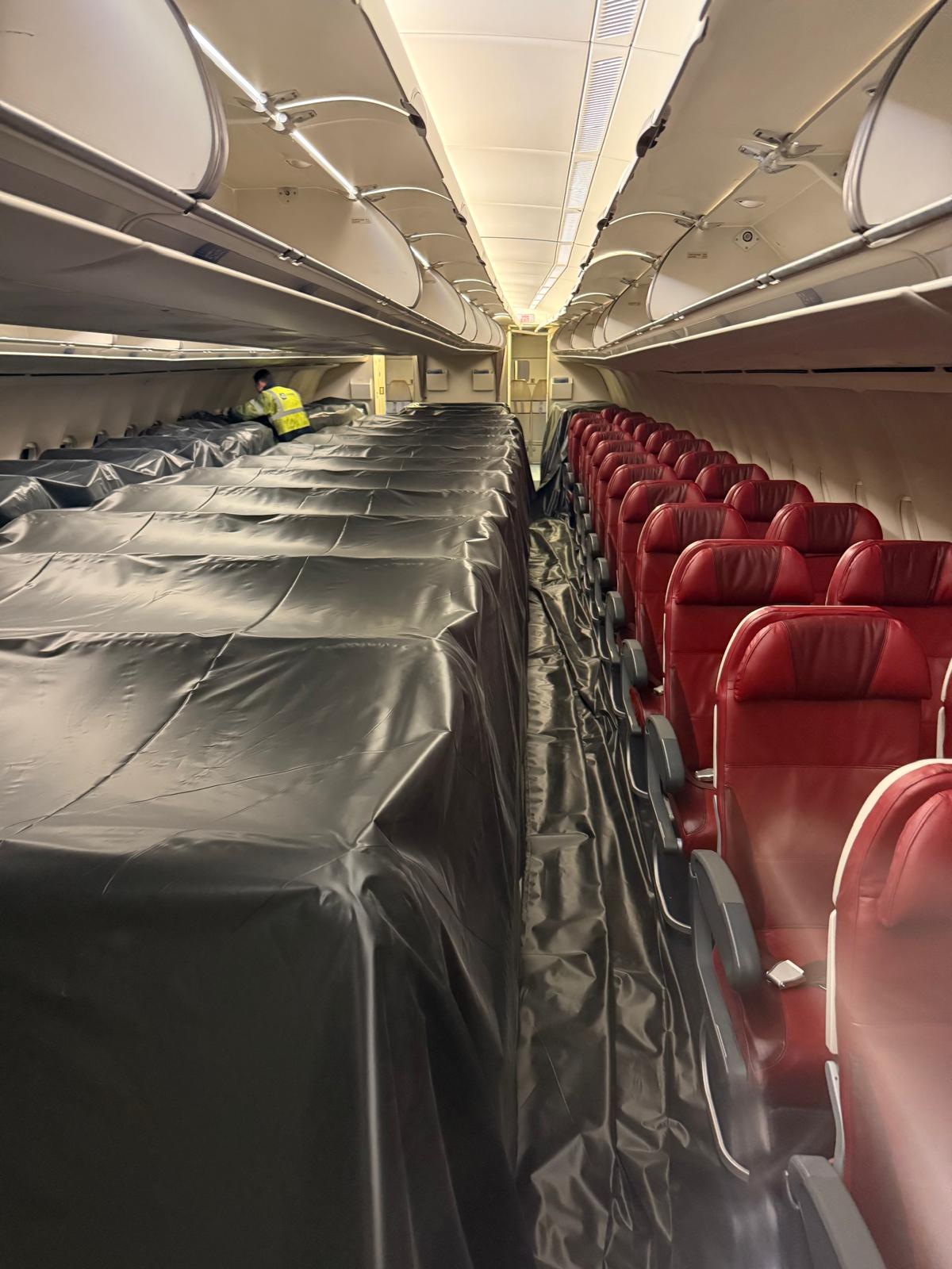 Cabin retrofit with new seats being installed, second view
