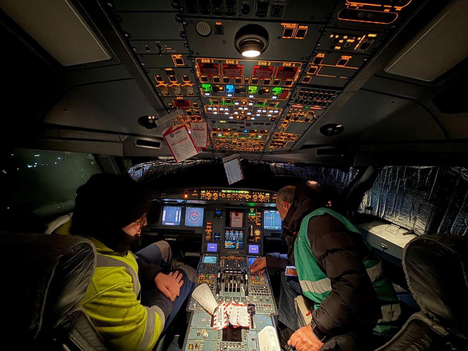 Technicians checking flight deck systems at night