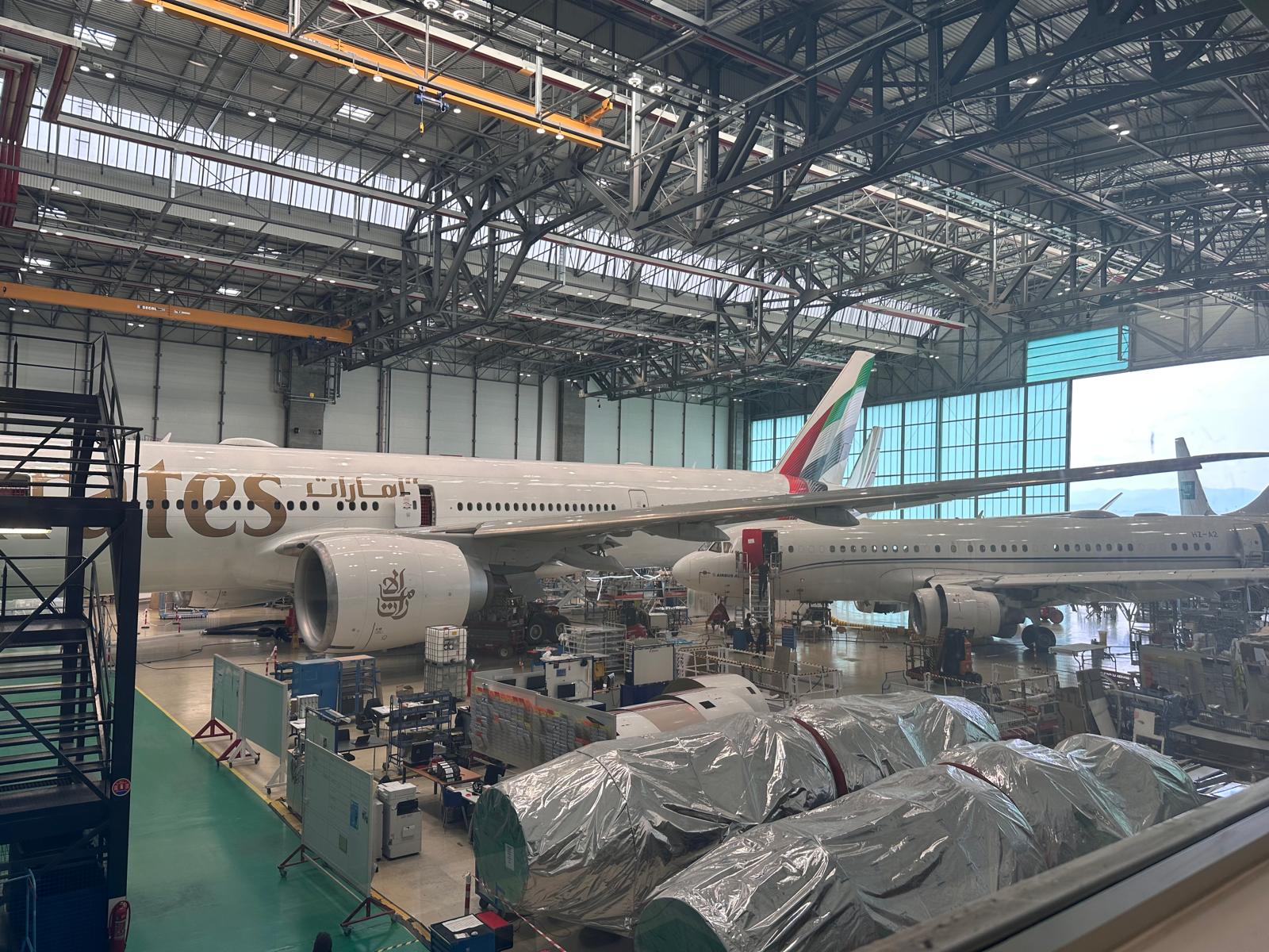 Wide-body aircraft undergoing heavy maintenance in a large hangar